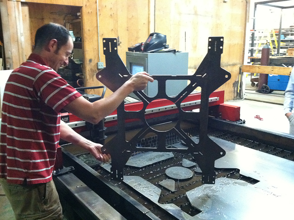 Eric Aston pulls stacker carriage part off plasma cutter