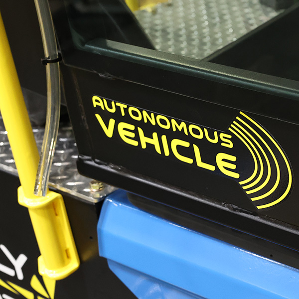 A close-up of a panel on the FireFly M220-AV mower with a decal reading "Autonomous Vehicle"