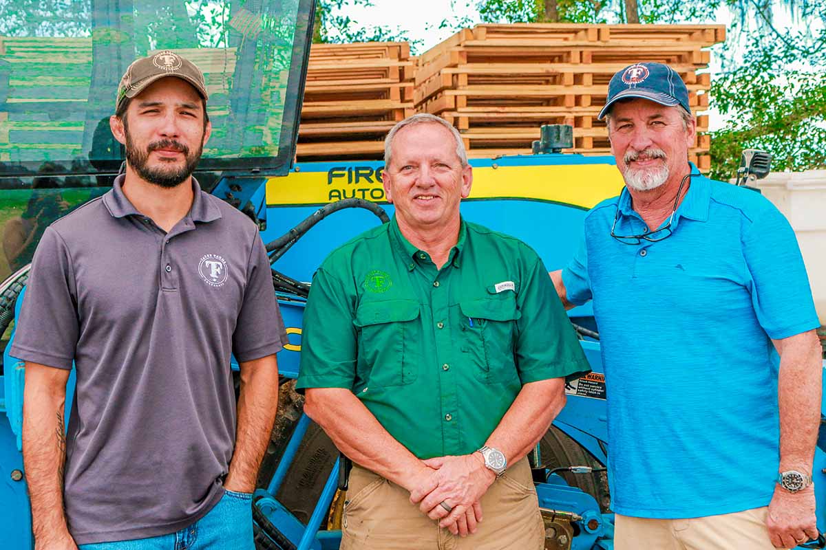 Gage Hjort, Pat Ditto, and Eric Hjort in front of FireFly harvester
