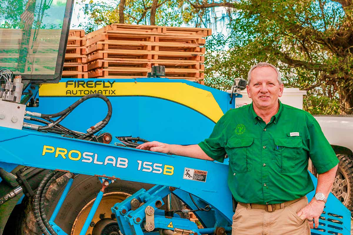 Pat Ditto in front of FireFly ProSlab 155B turf harvester