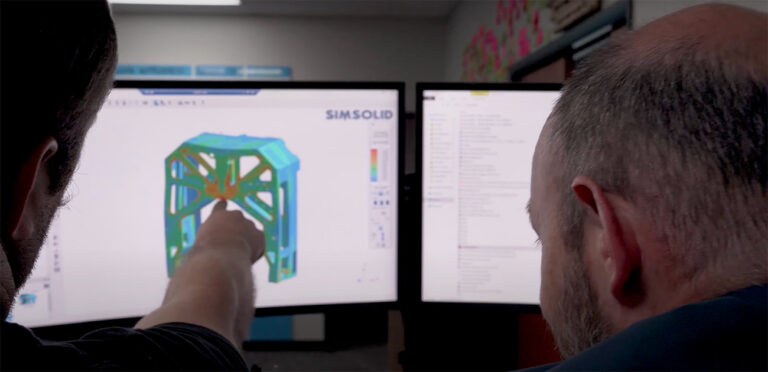 two engineers pointing at a computer screen showing test data