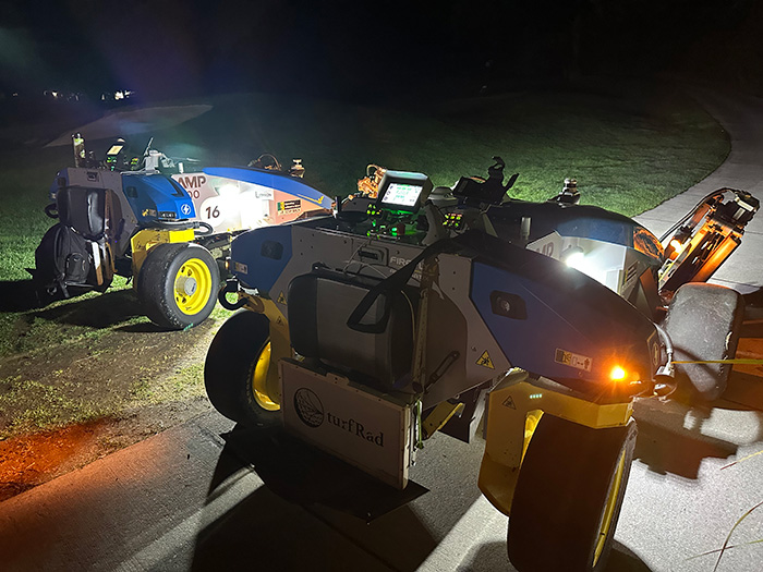 Two FireFly Automatix autonomous mowers in the dark