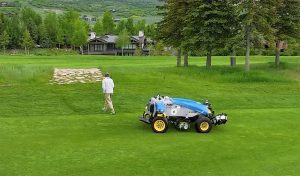 man walking away from AMP mower on golf course