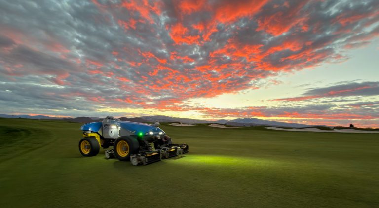 A FireFly robotic reel mower maintaining fairways for the Bank of Utah Championship at sunset